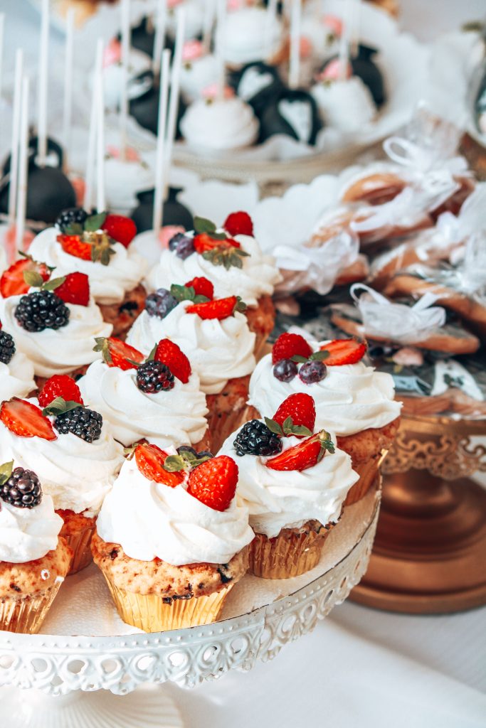 A tempting display of beautifully decorated cupcakes with fresh berries on a stand.
